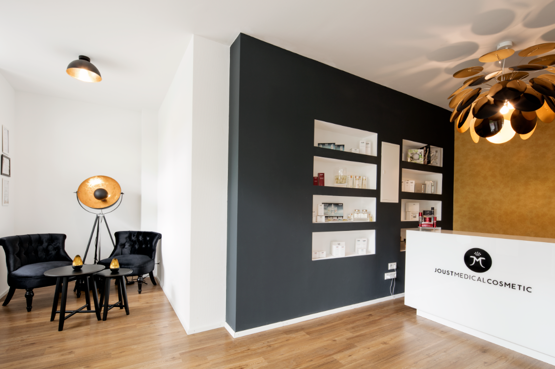 Empfangsbereich mit Wartelounge und Produktregal bei Joust Medical Cosmetic in Ludwigsburg
